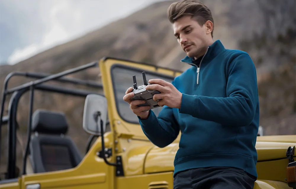 DJI RC 2 controller in outdoor mountain scenery