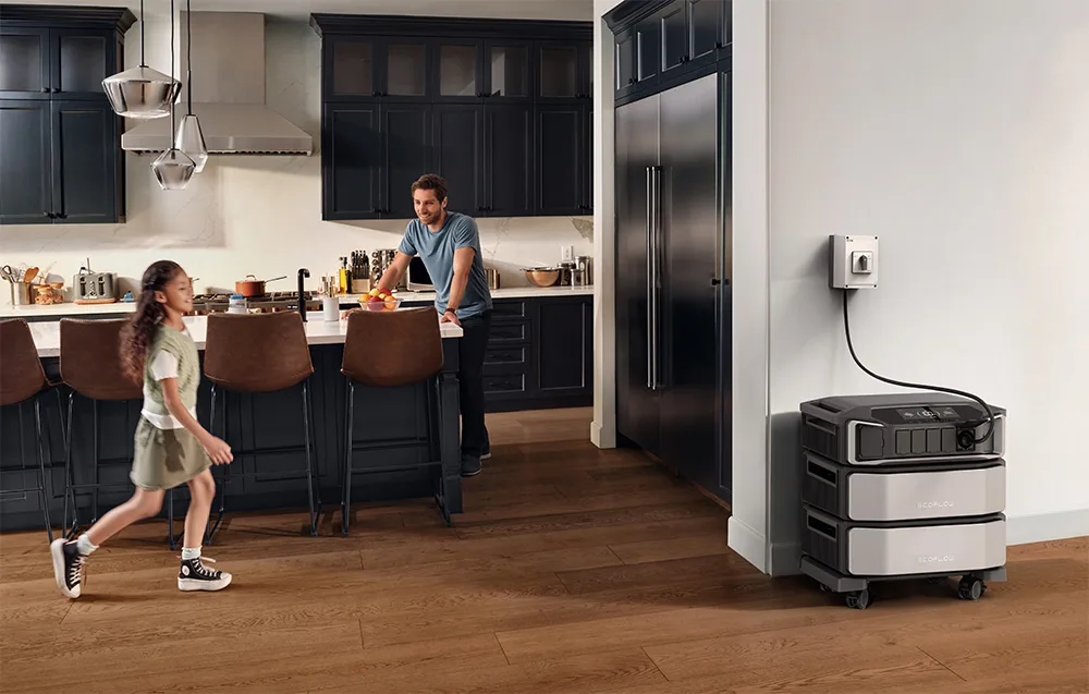 Family in a kitchen with an EcoFlow home backup power system connected near the wall outlet