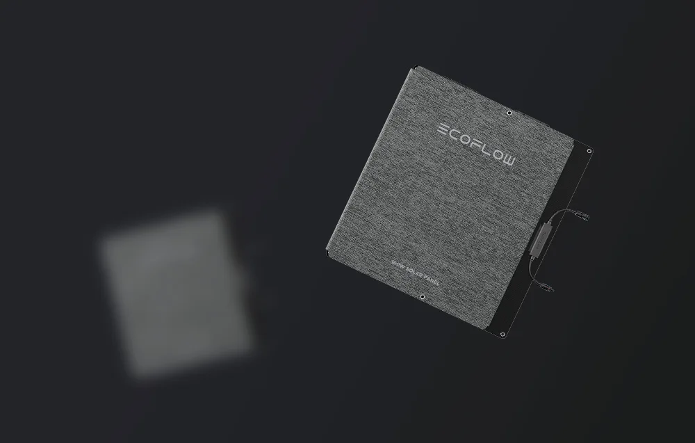 Two folded solar panels in gray carrying bags on black background