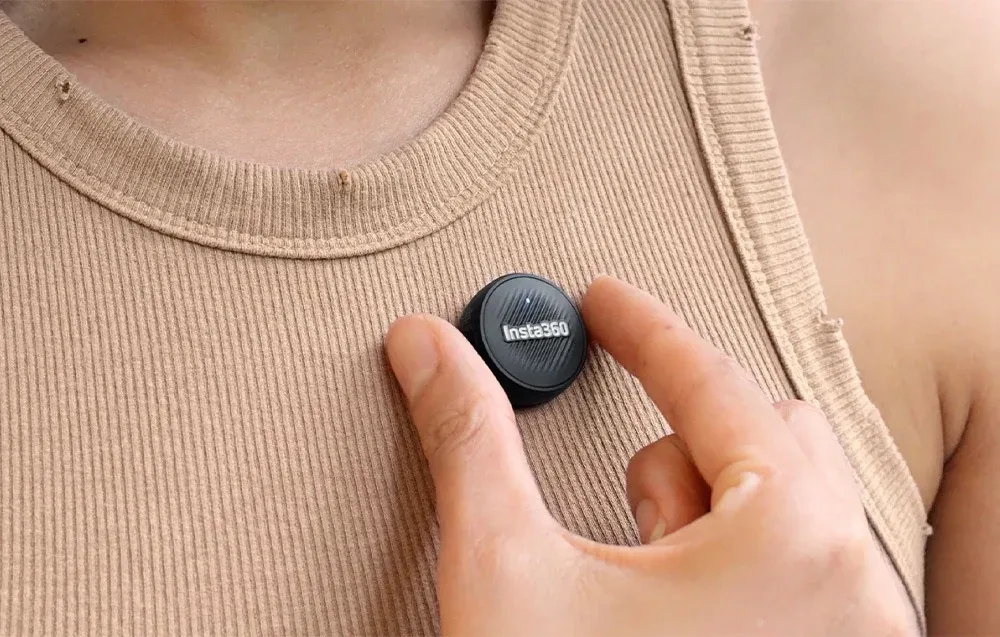 Користувач закріплює передавач Insta360 Mic Air на футболці