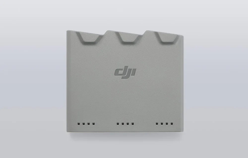 Зарядний хаб DJI Mini 5 Pro з трьома верхніми слотами, логотипом по центру та світлодіодними індикаторами внизу