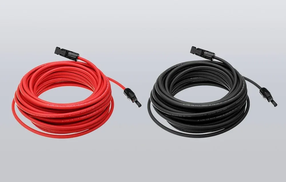 Red and black solar extension cables with MC4 connectors coiled on a gray background