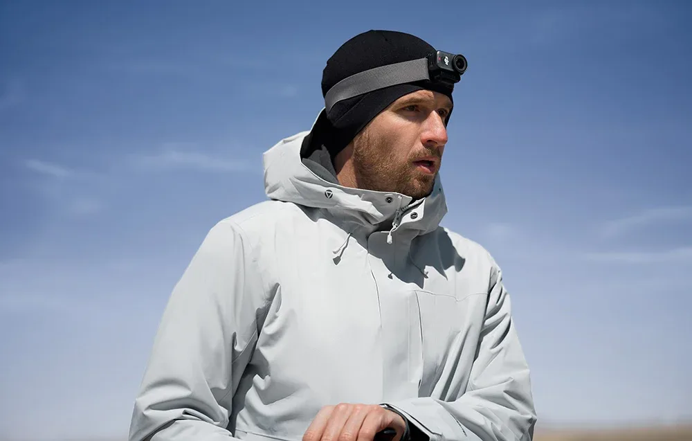 Man wearing a winter jacket and hat with the DJI Osmo Nano headband and mounted camera