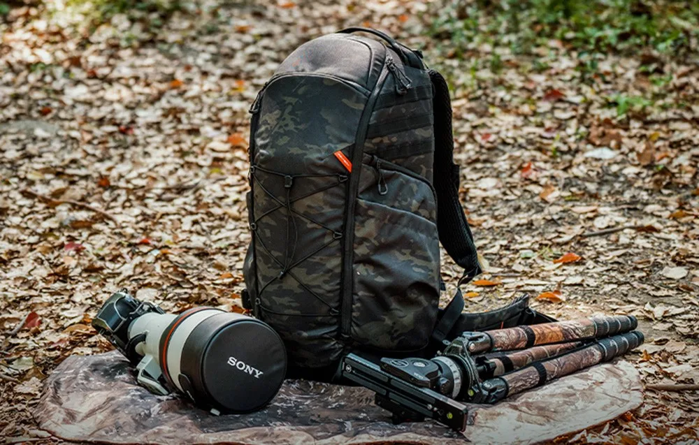 PGYTECH OnePro ST backpack in a forest next to a large lens and folded tripod