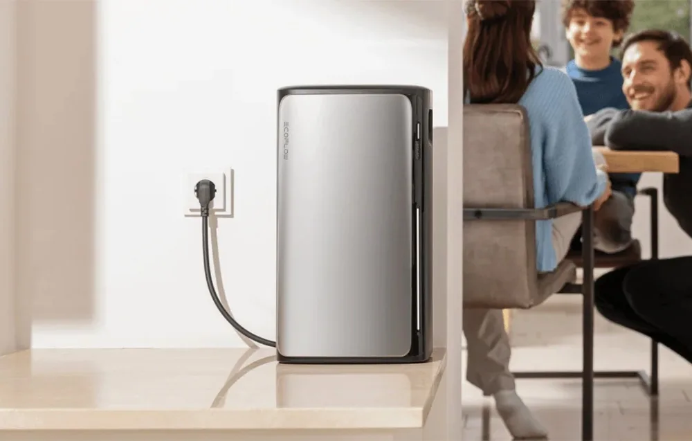 Silver EcoFlow STREAM AC energy storage unit connected to a wall socket in a bright interior