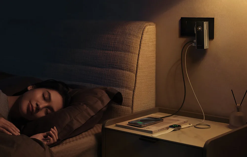 Woman sleeping next to a nightstand with a smartphone and smartwatch connected to the EcoFlow power bank.
