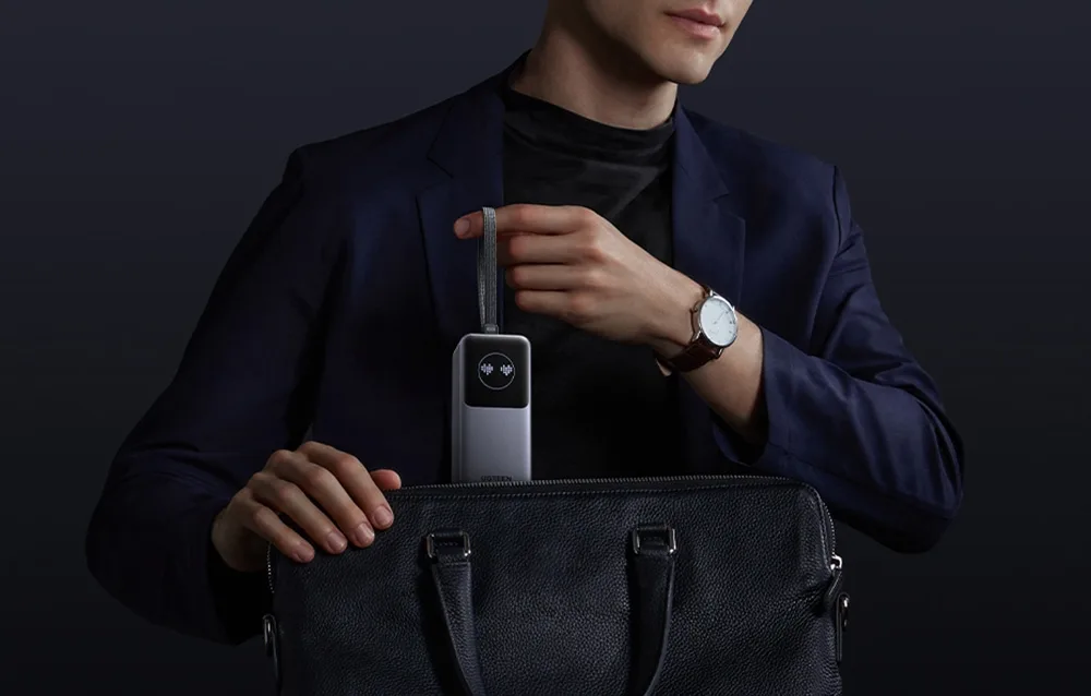 Man placing the Ugreen PB723 power bank into a bag using the strap