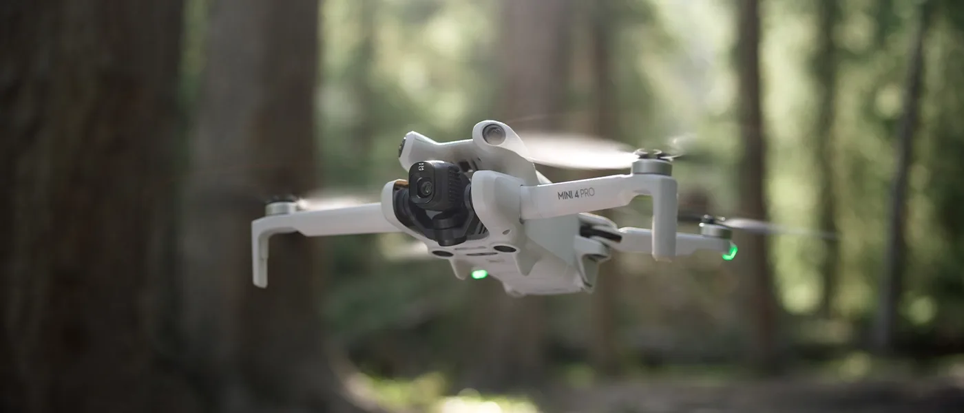 DJI Mini 4 Pro flying above woodland scenery