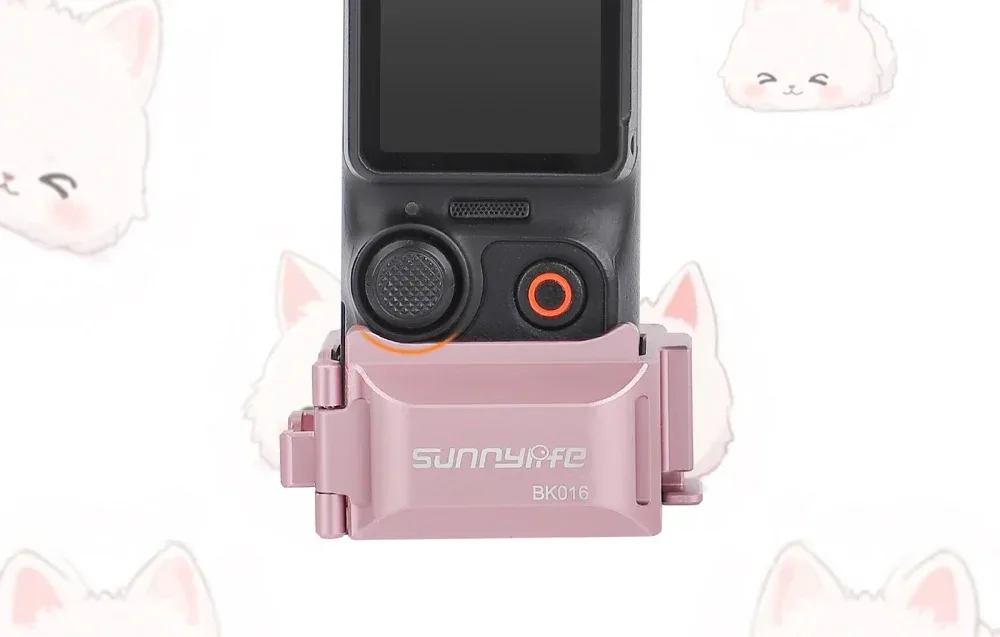 Zbliżenie dolnej części kamery DJI Pocket zamontowanej w różowym uchwycie Sunnylife BK016 na tle rysunkowych kotów
