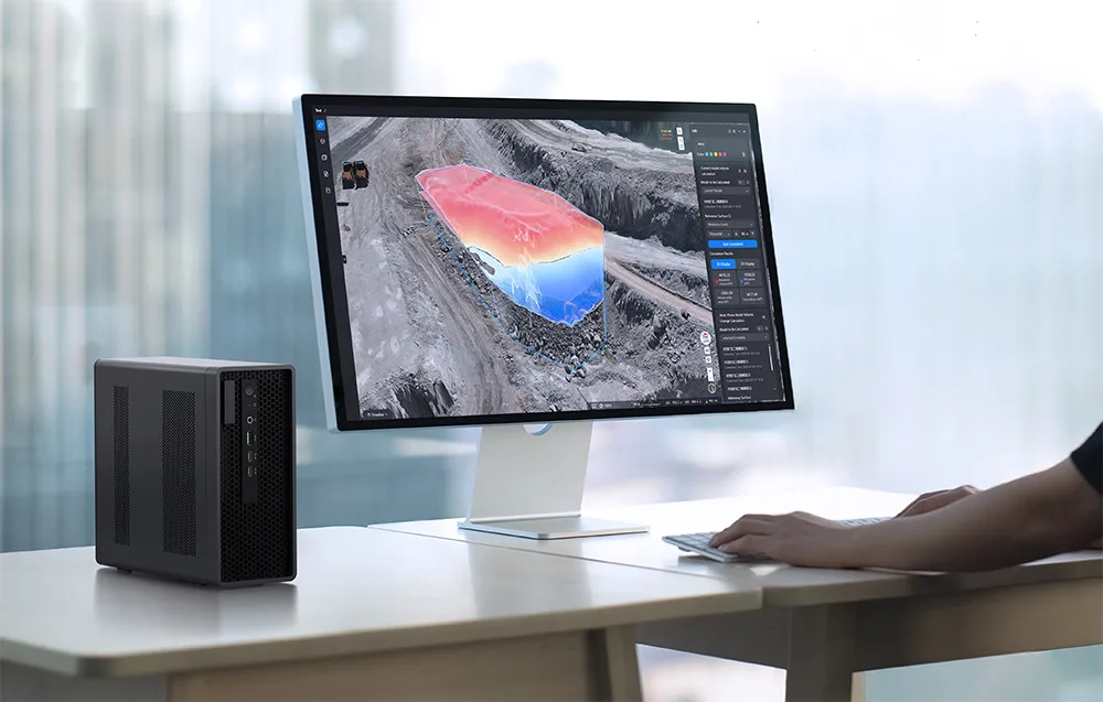Monitor z wizualizacją 3D geologicznej mapy terenu obok kompaktowego komputera na jasnym biurku