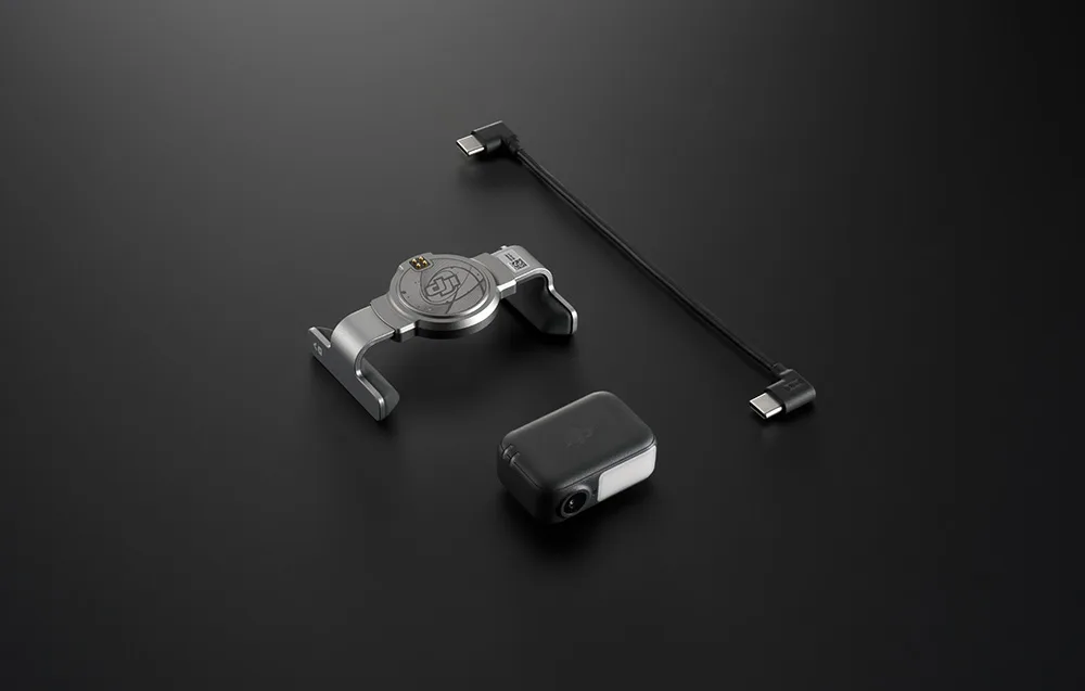 Uchwyt montażowy DJI, moduł bezprzewodowy i przewód USB-C ułożone na czarnym tle
