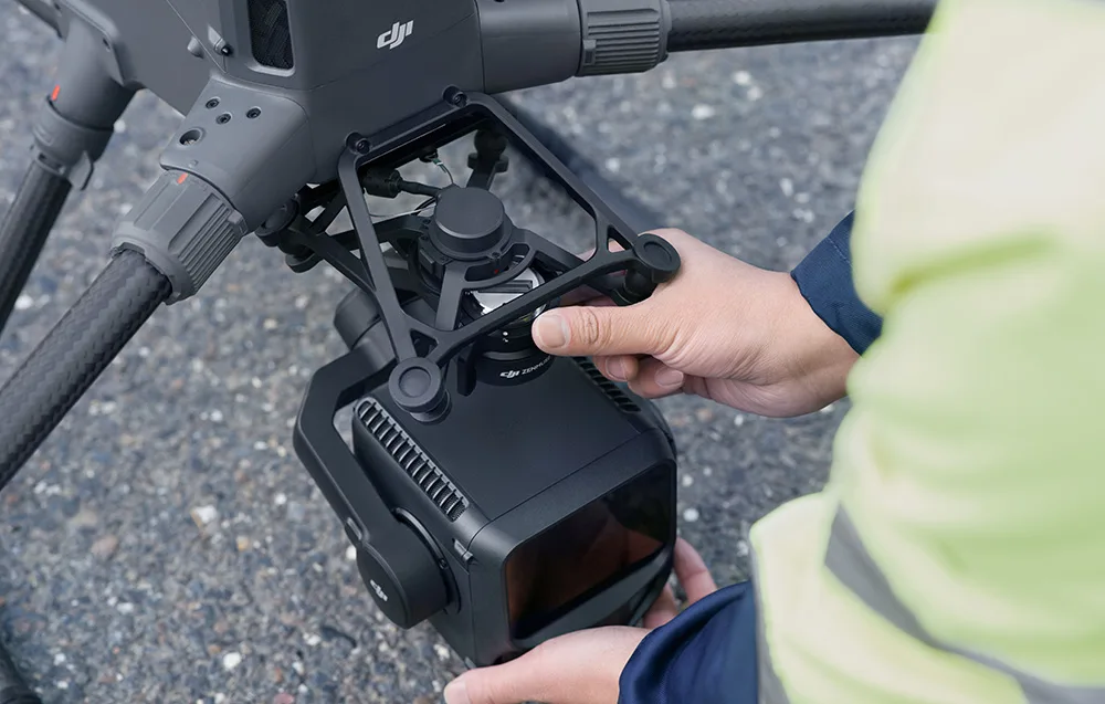Hands mounting the DJI Zenmuse L3 camera onto a drone