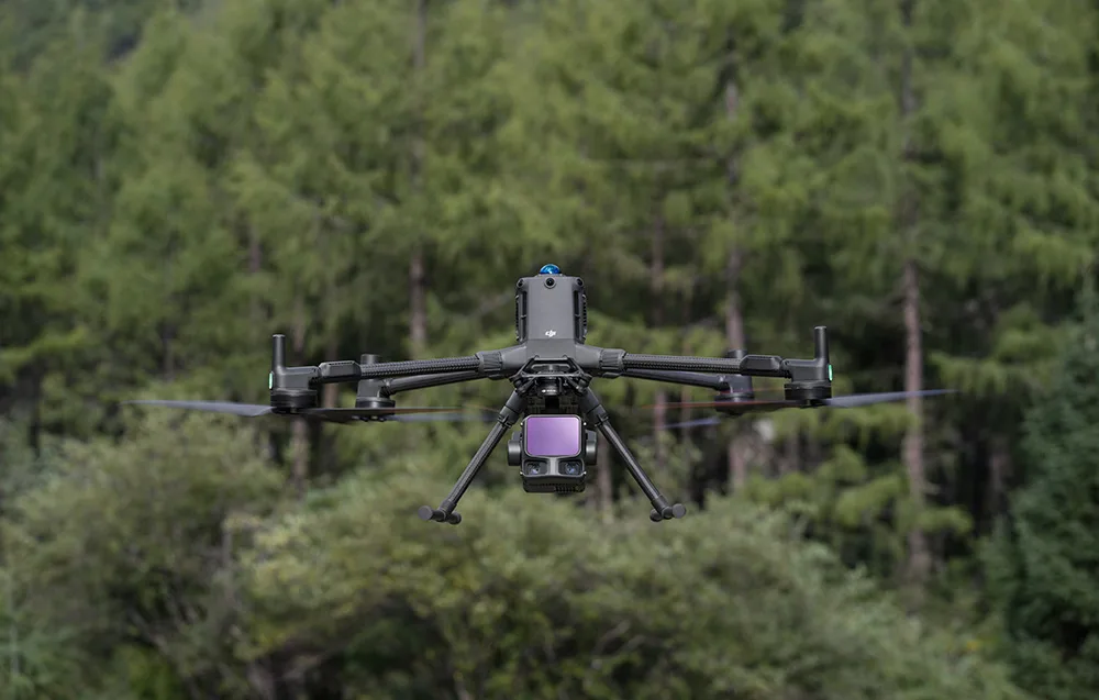 Drone equipped with DJI Zenmuse L3 flying above a dense forest