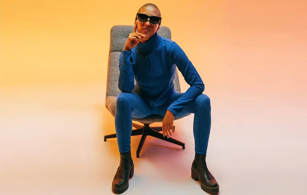 Person in sporty blue clothing wearing VITURE XR Luma glasses in a colorful studio setting