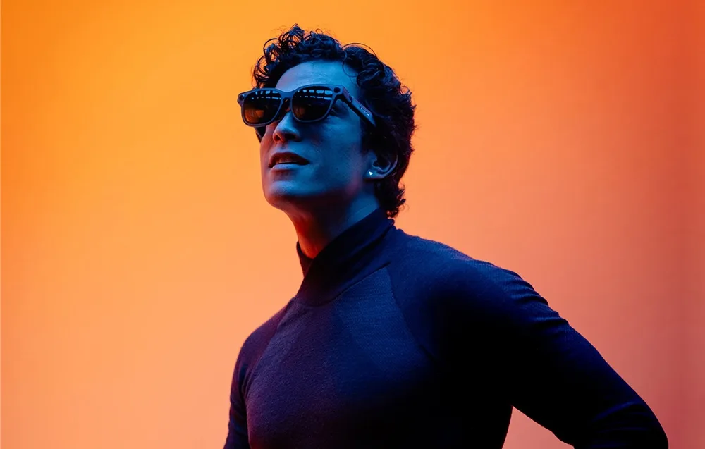 Man wearing VITURE XR Luma Ultra glasses on an orange background