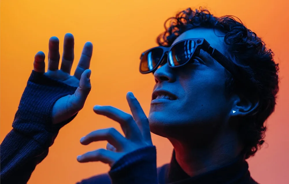 Person wearing VITURE XR Luma Ultra glasses on an orange background
