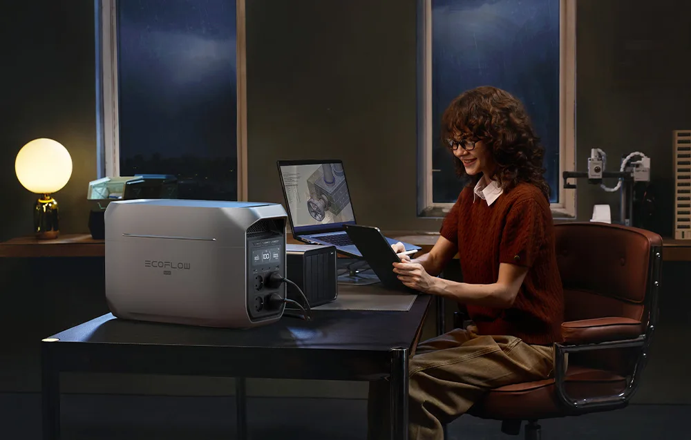 Woman working in the evening with a tablet at a desk next to the EcoFlow DELTA 3 Max Plus power station.