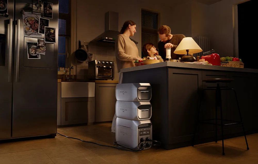 Family cooking in the evening kitchen with the EcoFlow power station and additional batteries next to the kitchen island.
