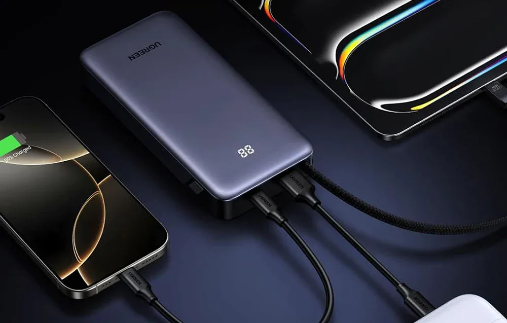 UGREEN power bank connected to a smartphone and tablet.