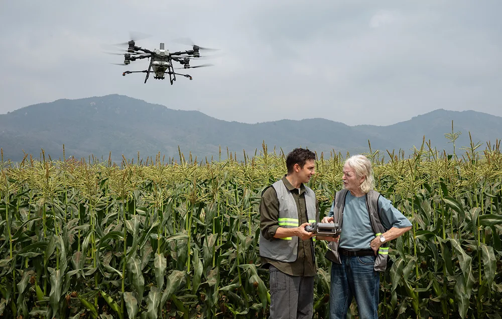 Dwóch operatorów i dron rolniczy nad polem