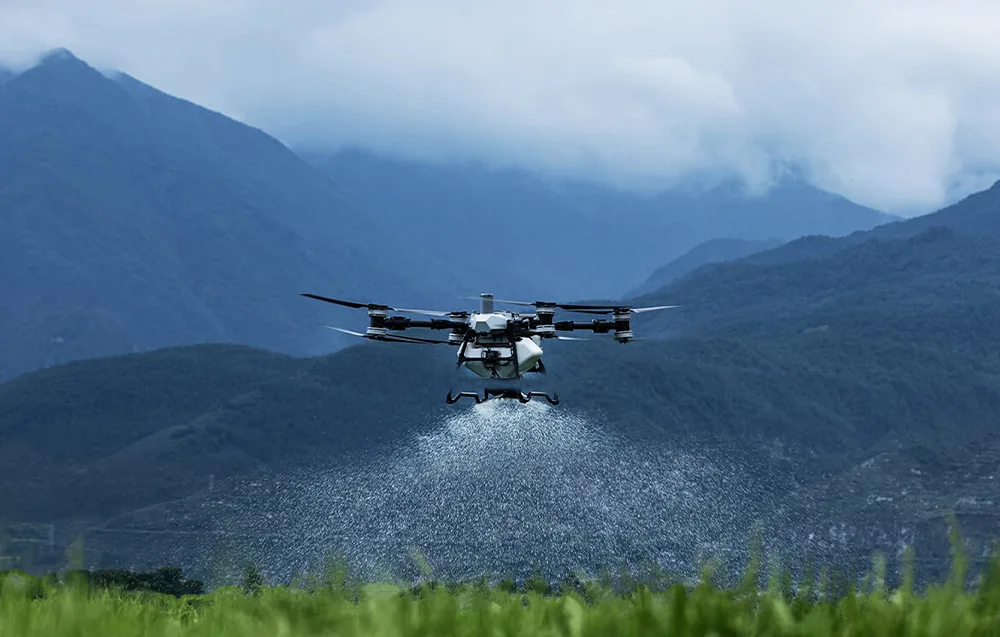 Dron rolniczy DJI Agras T100 opryskujący pole