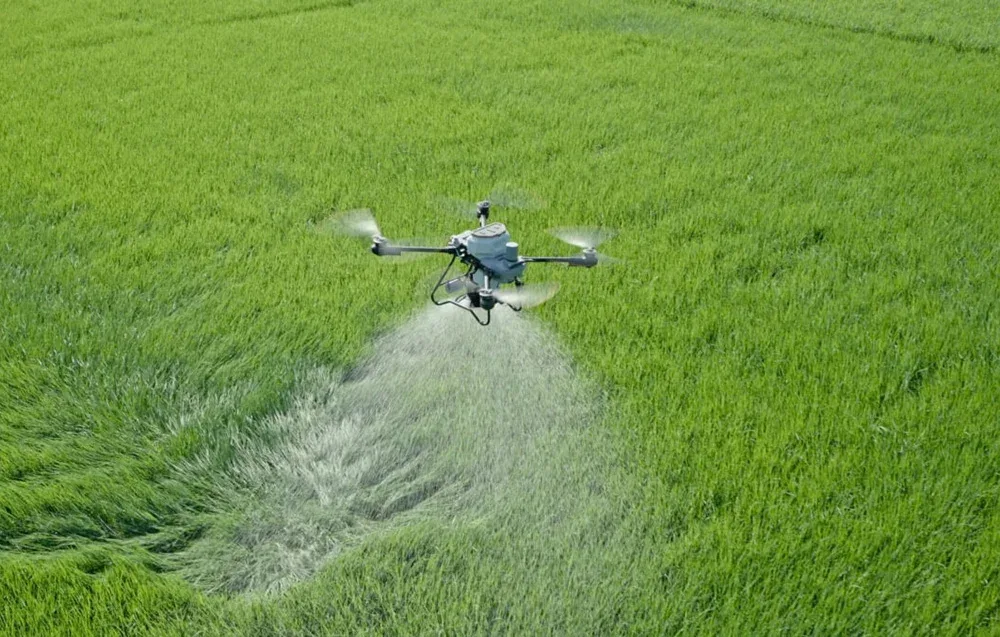 Dron rolniczy podczas oprysku zielonego pola