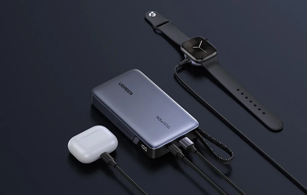 Gray UGREEN power bank connected to a smartwatch and TWS earbuds on a black background