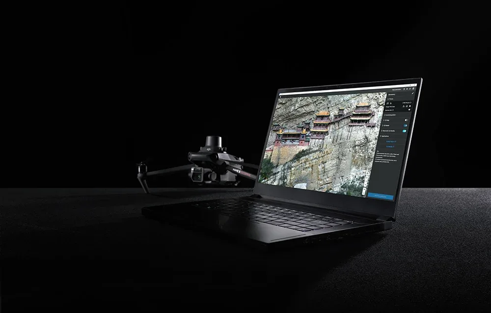 dron i laptop z włączonym oprogramowaniem do rekonstrukcji 3D na czarnym tle