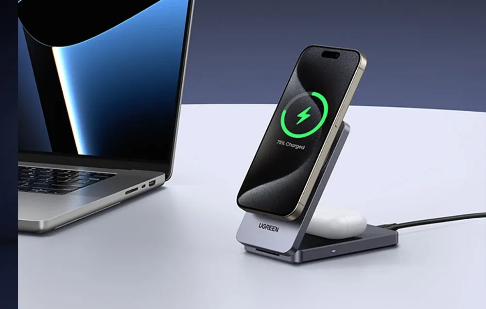 UGREEN W706 2-in-1 charger charging a smartphone and TWS earbuds on a desk next to a laptop