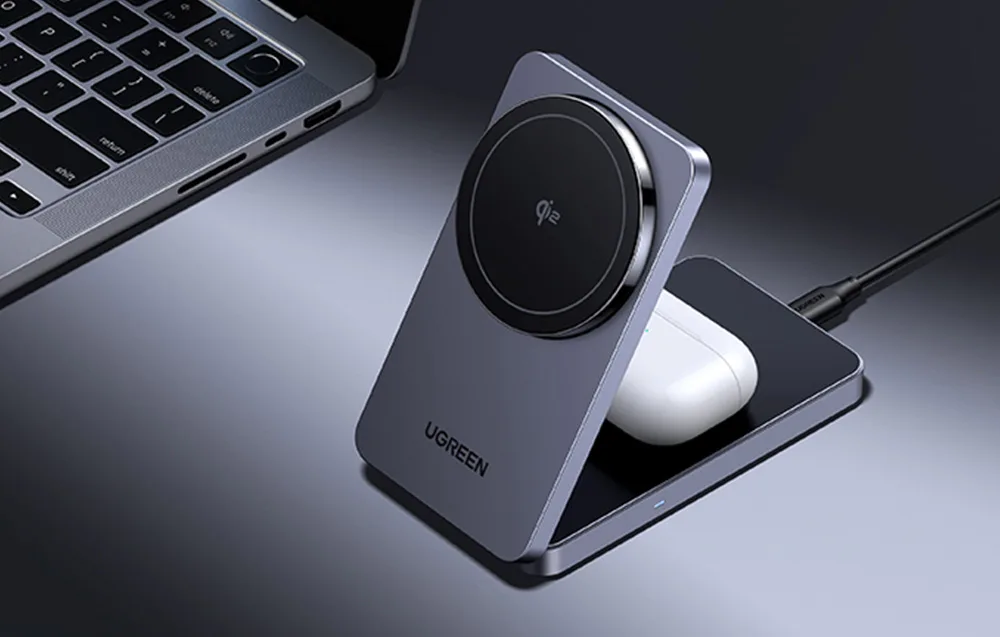 UGREEN W706 wireless charger with TWS earbuds placed on a desk next to a laptop