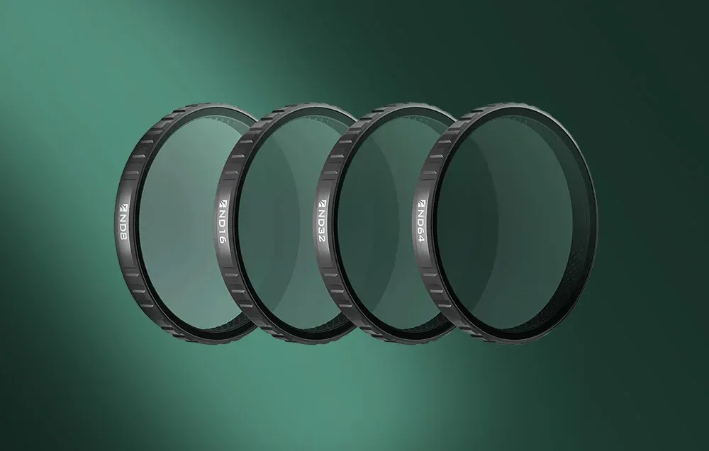 Zestaw czterech filtrów Freewell (ND8, ND16, ND32, ND64) ułożonych w rzędzie na zielonym tle.
