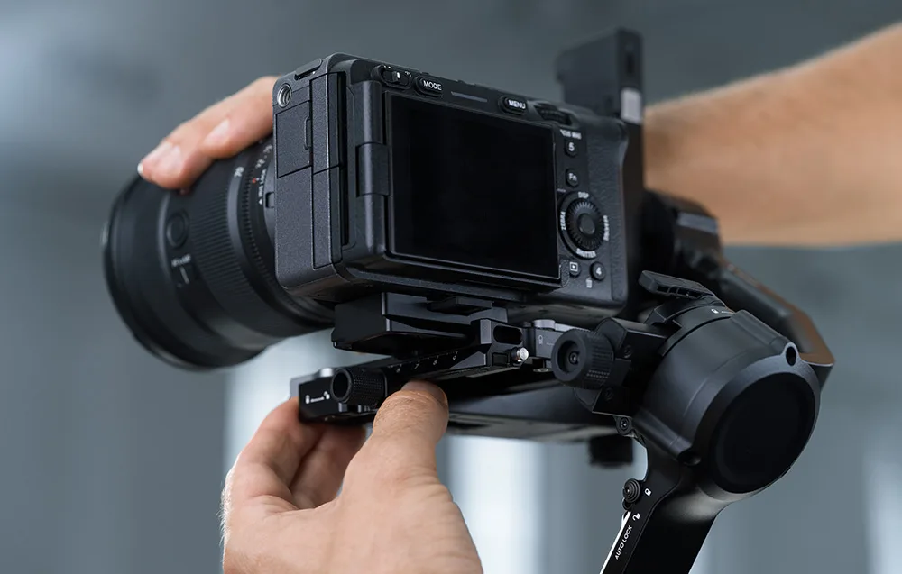 Hands adjusting a camera mounted on a DJI gimbal