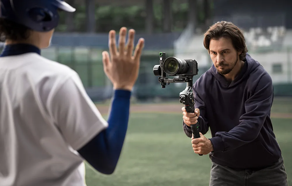 Person filming with a camera mounted on a DJI gimbal stabilizer