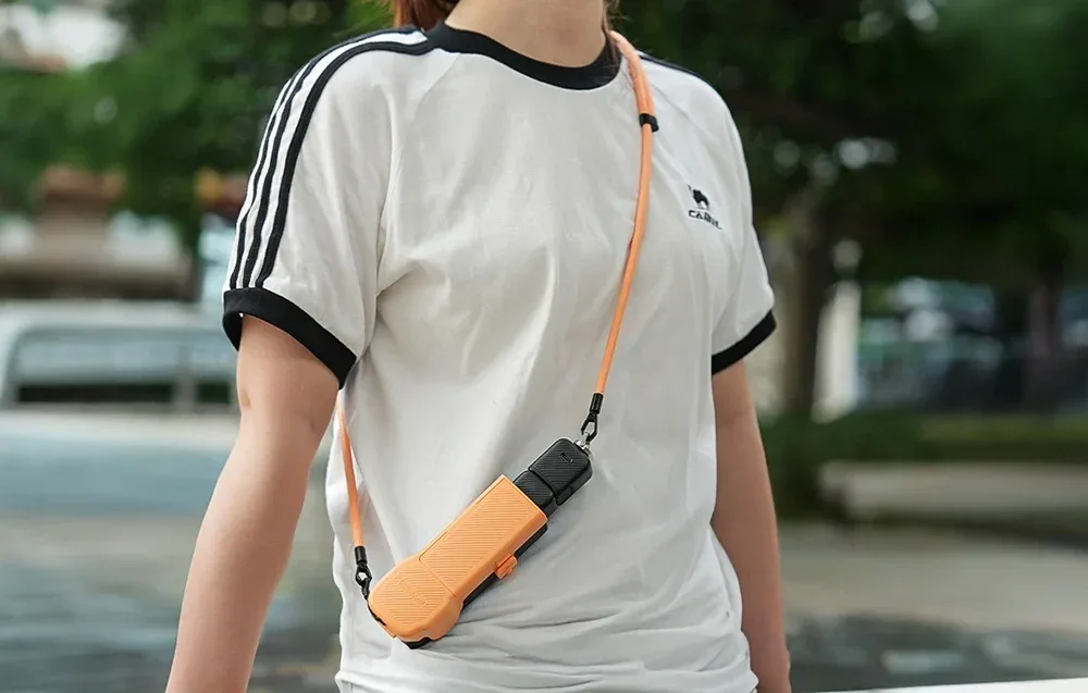 Woman wearing a white T-shirt with a camera hanging around her neck on the Sunnylife strap