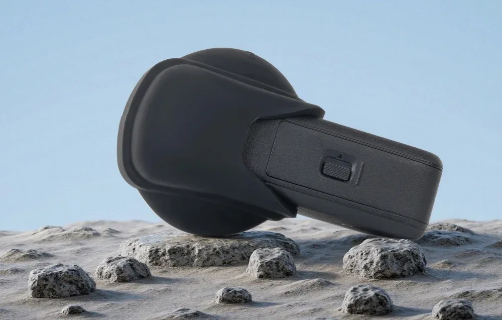 Спортивна камера DJI Osmo 360 із силіконовою накладкою на об’єктив, розміщена на камінні