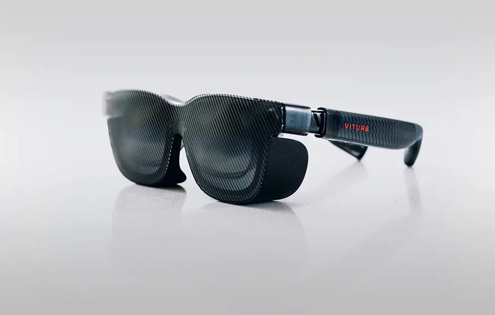 Black XR glasses with sun shield mounted on a gray background