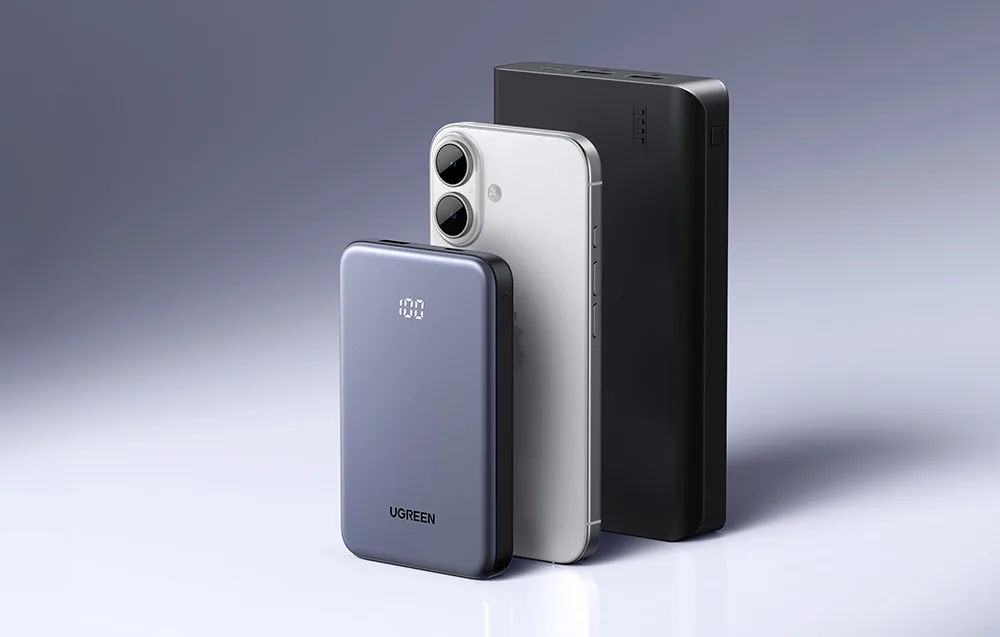 Powerbank Ugreen obok smartfon i drugiego powerbanka na szarym tle