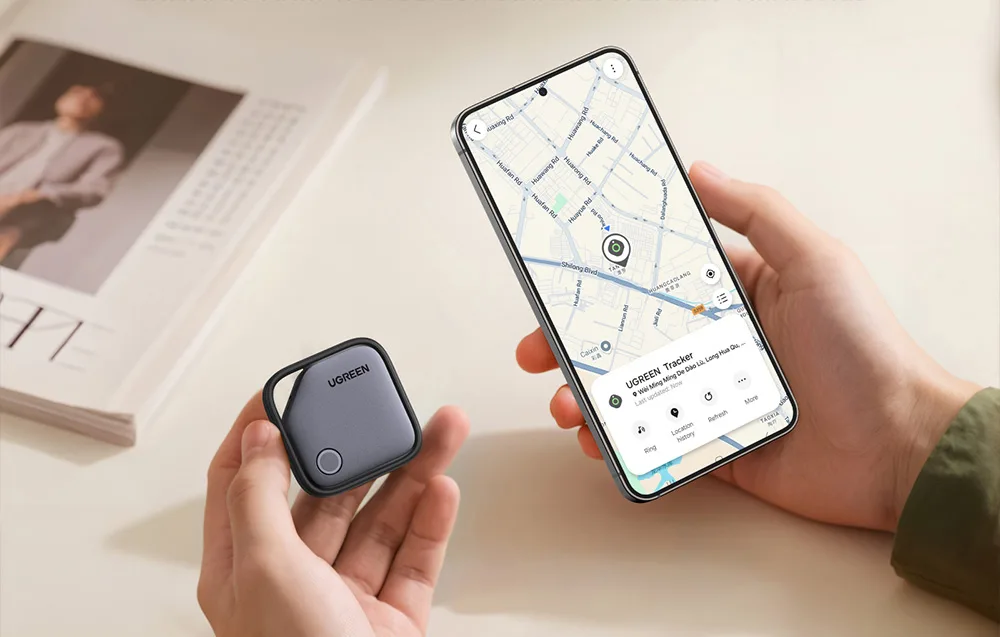 Локатор UGREEN у руці та смартфон Samsung з відкритою картою