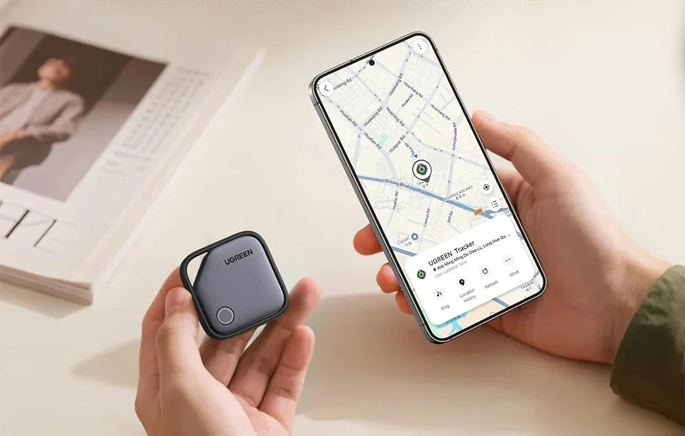 Локатор UGREEN у руці та смартфон Samsung з відкритою картою пошуку