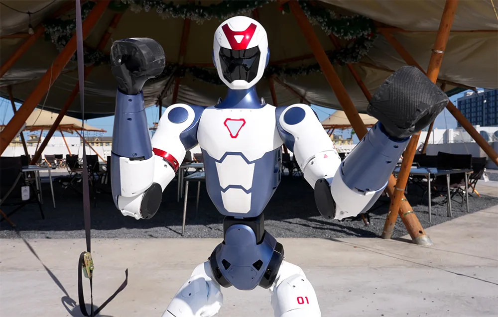 Close-up of the UNITREE R1 Basic humanoid robot in a fighting stance with raised fists