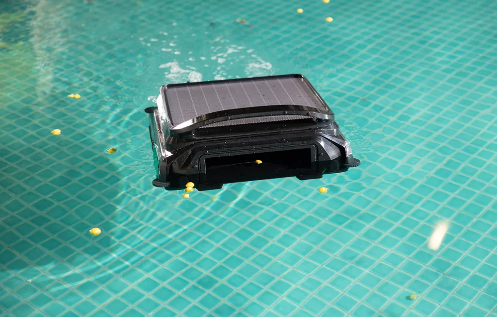 WYBOT F1 cordless pool robot cleaning a pool with visible leaves and debris