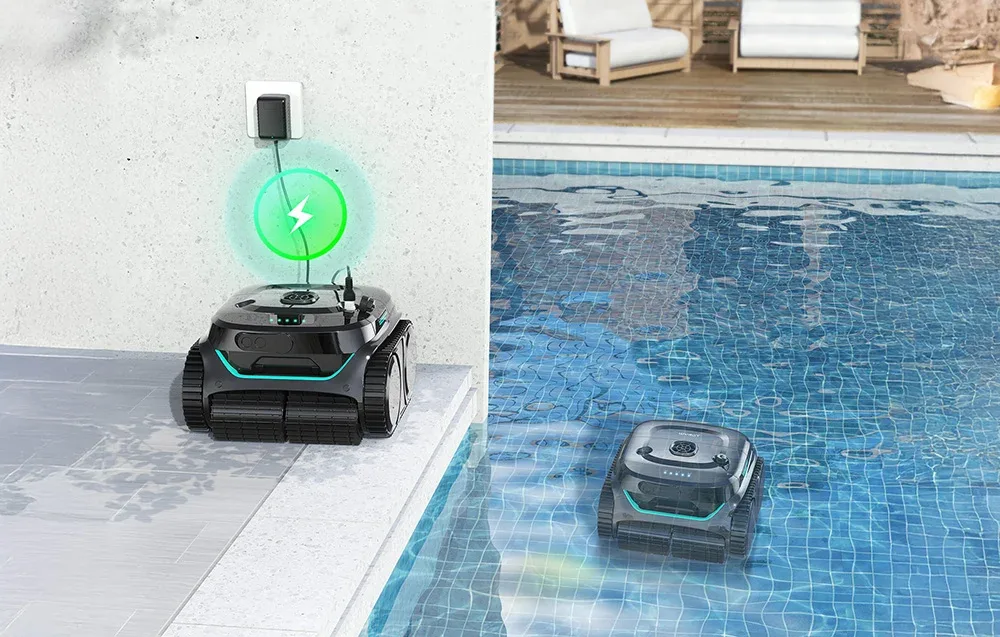 Two Wybot C2PRO cordless pool cleaning robots, one charging by the pool and one cleaning the pool floor