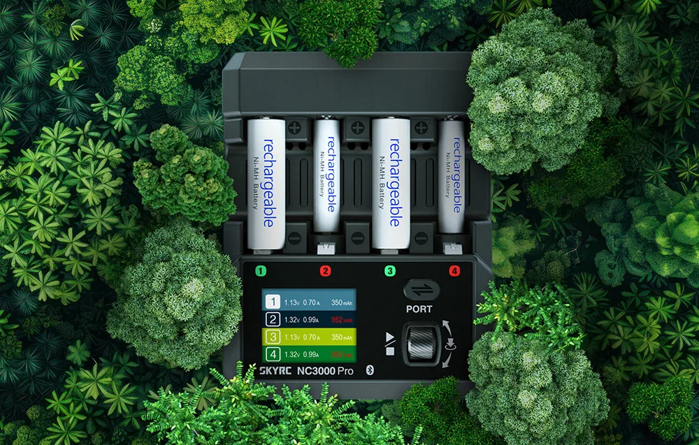 Ładowarka SkyRC NC3000 Pro z akumulatorami otoczona zieloną roślinnością.