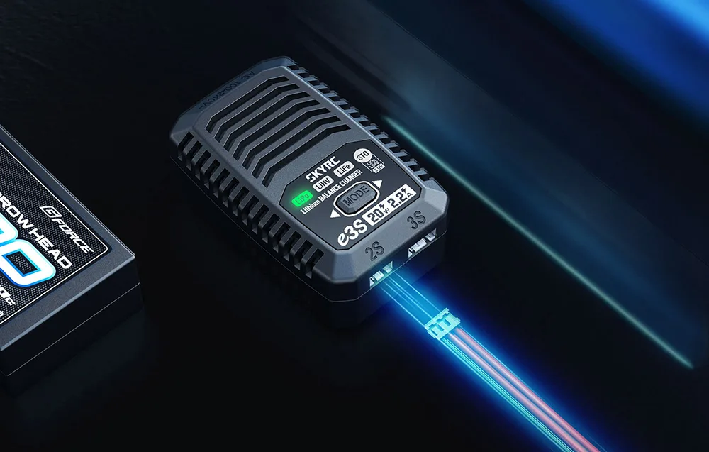 Ładowarka SKYRC e3S z podłączonym przewodem balansującym obok akumulatora modelarskiego.