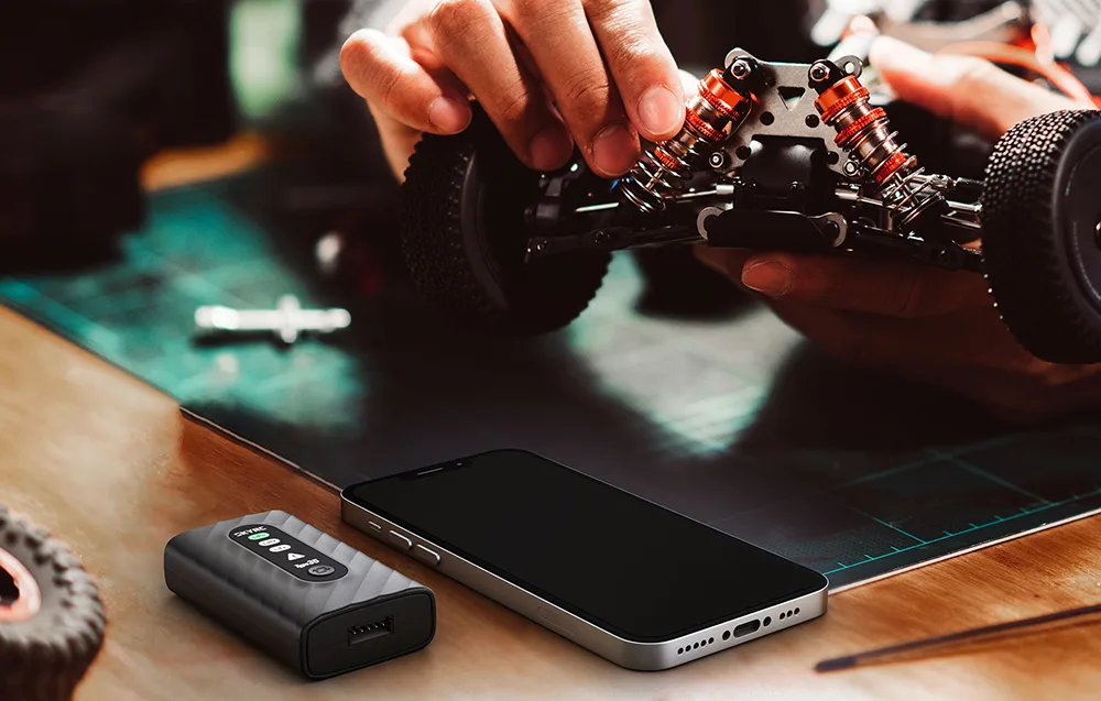 SkyRC Type35 charger on a desk next to a smartphone during RC model work.