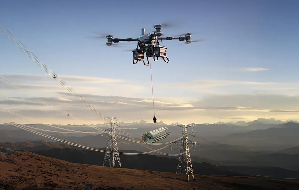 Dron transportowy podnoszący ciężki ładunek nad liniami energetycznymi w górach