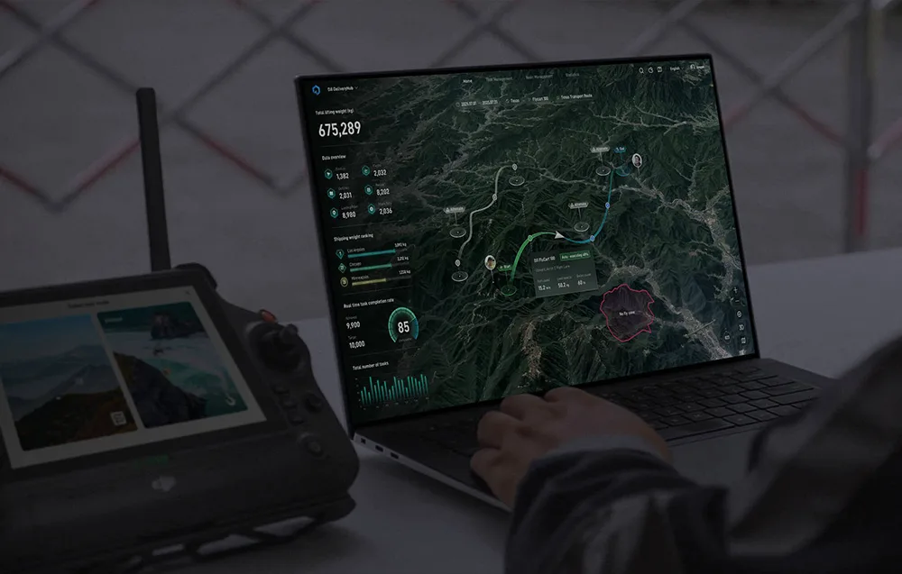 Operator sterujący dronem przy laptopie z mapą i trasą lotu