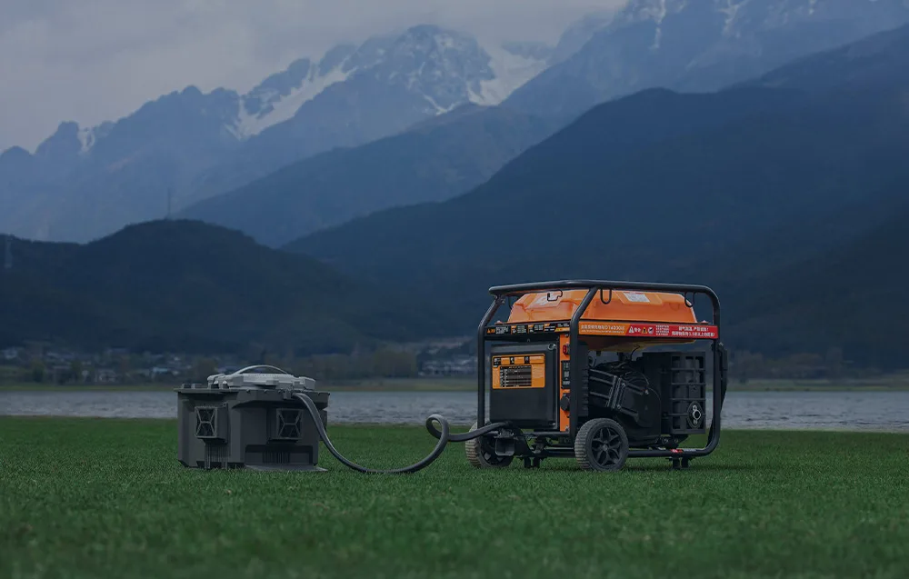 Generator prądu podłączony do skrzynki zasilającej stojący na trawie w górach