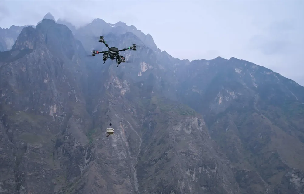 Dron transportowy przenoszący ładunek nad górskim terenem