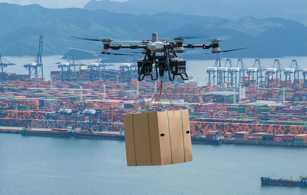 Dron transportowy unoszący się nad portem kontenerowym, przenoszący na linkach duże, brązowe pudło cargo